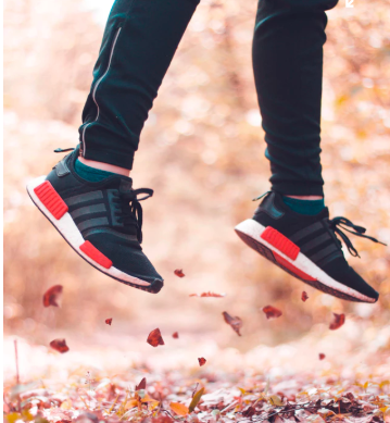 person jumping in autumn leaves
